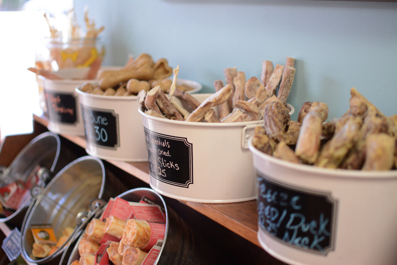 dog treats sit in buckets on store shelves